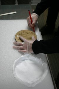 Manufacture of a foam tray for the packaging of a plaster bas-relief.